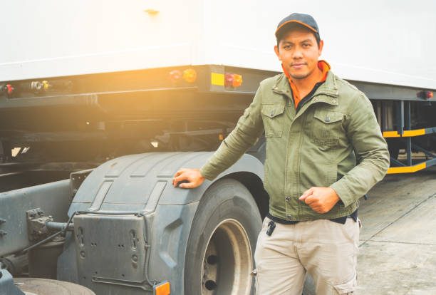 Portrait of truck driver with semi truck trailer, freight industry logistics and transport